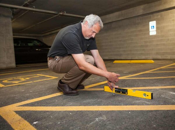 Richard Seneczko measuring the slope of an accessible parking space.