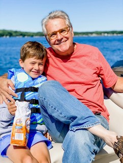 Doug Mohnke sitting with his grandson at the lake.