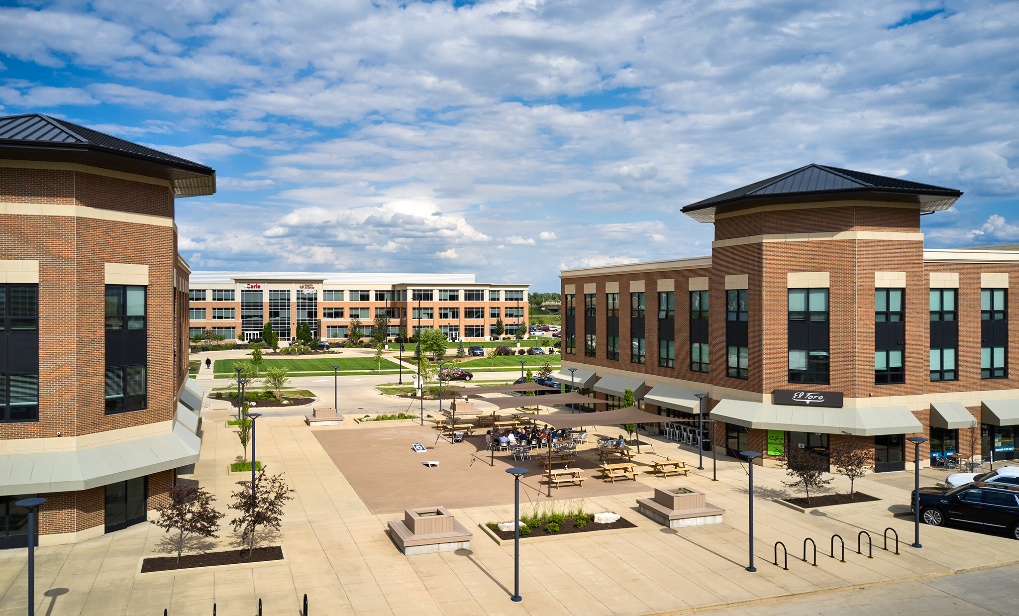 Two symmetrical three-story buildings of Field South development with an outdoor plaza between them.