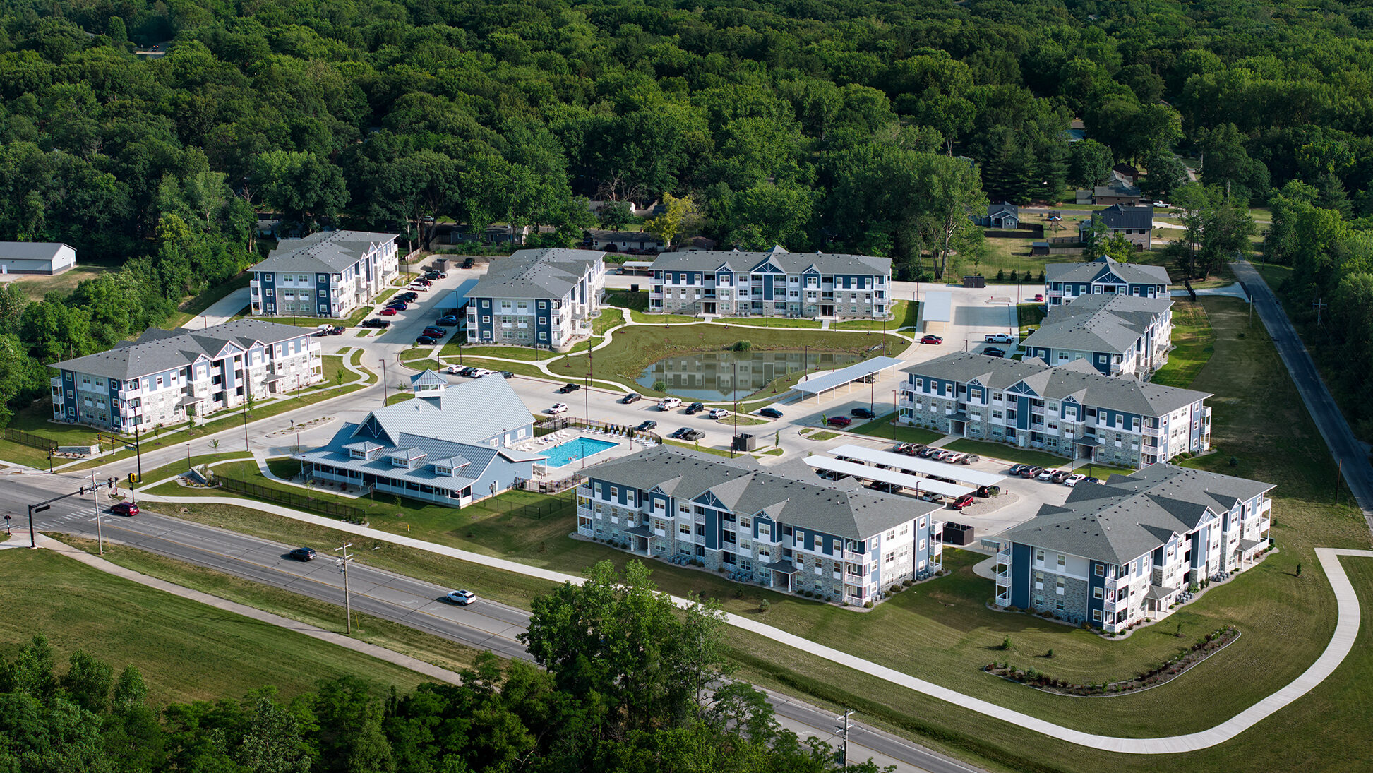 Aerial view of Solace of Mahomet development with a central pond and pool.