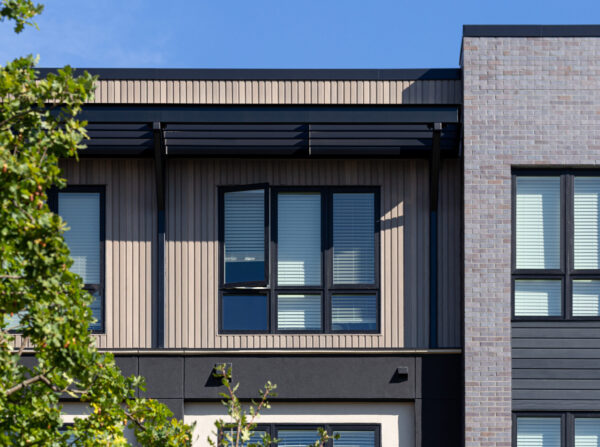 Close up view of building facade showing window, screen, and brick details.