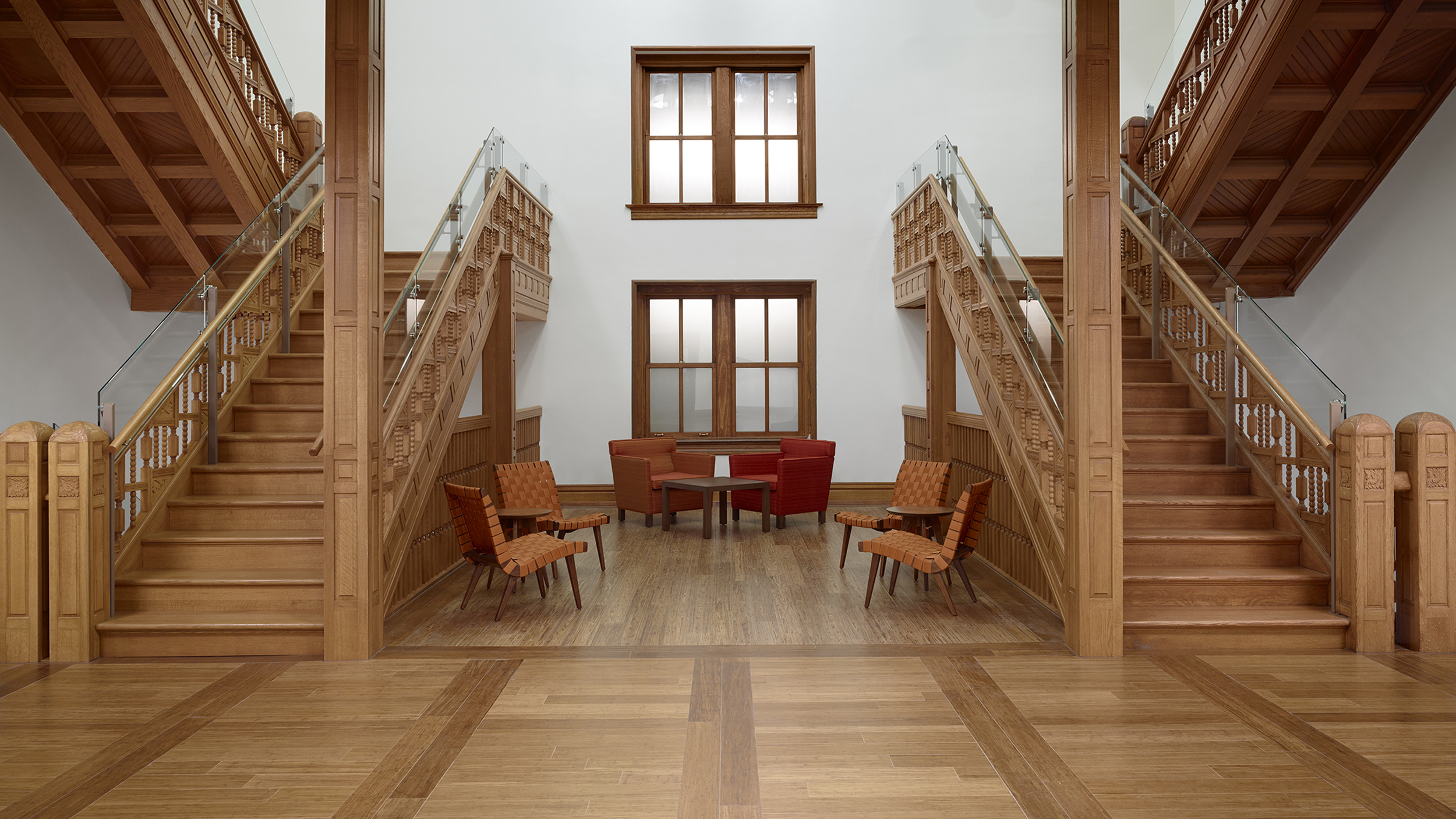 Symmetrical ornately carved wooden stairways restored in Natural History Building.