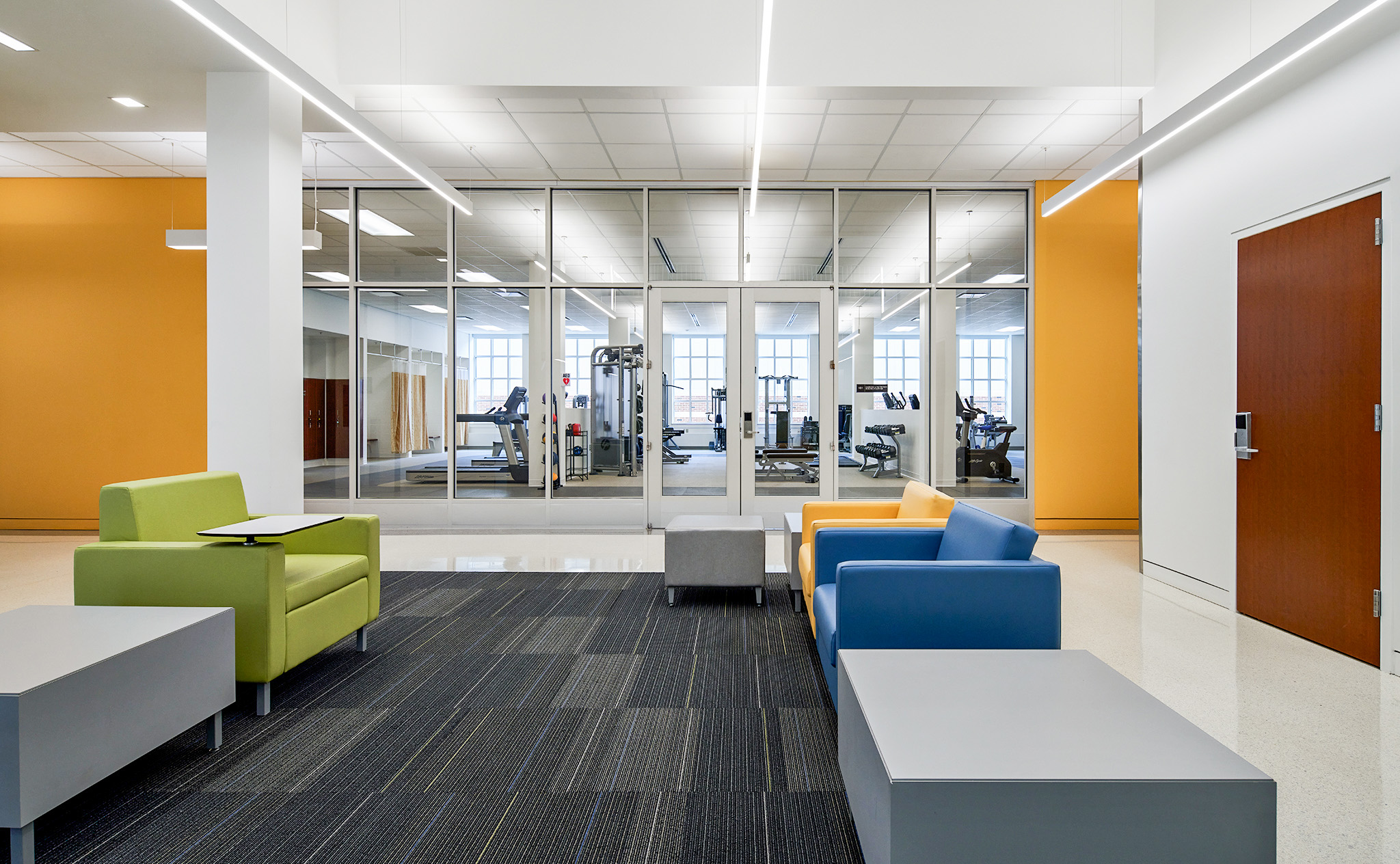 Freer Hall lobby seating with fitness center in the backdrop.