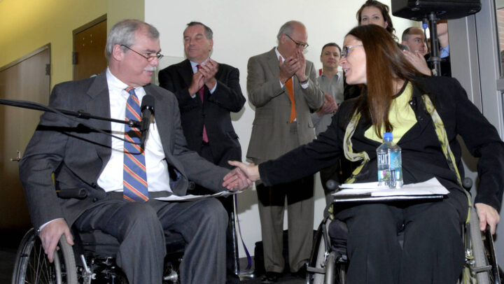 LCM co-founder Jack Catlin shaking hands with Access Living founder Marca Bristo.