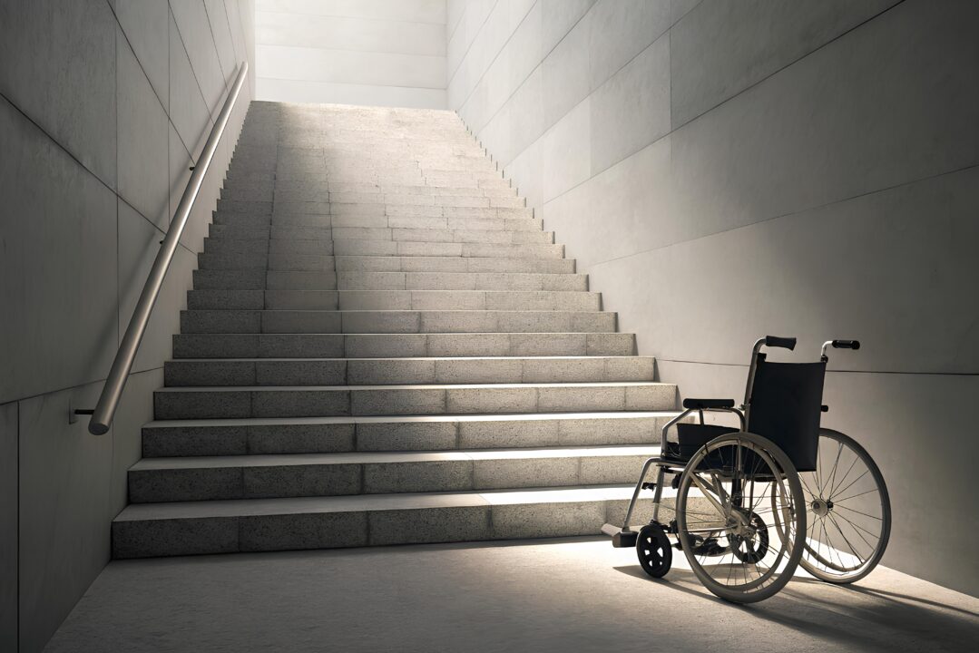 A wheelchair in front of a staircase.