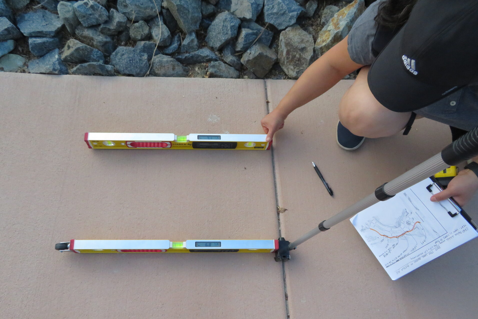 Accessibility survey measuring the slope of the sidewalk.