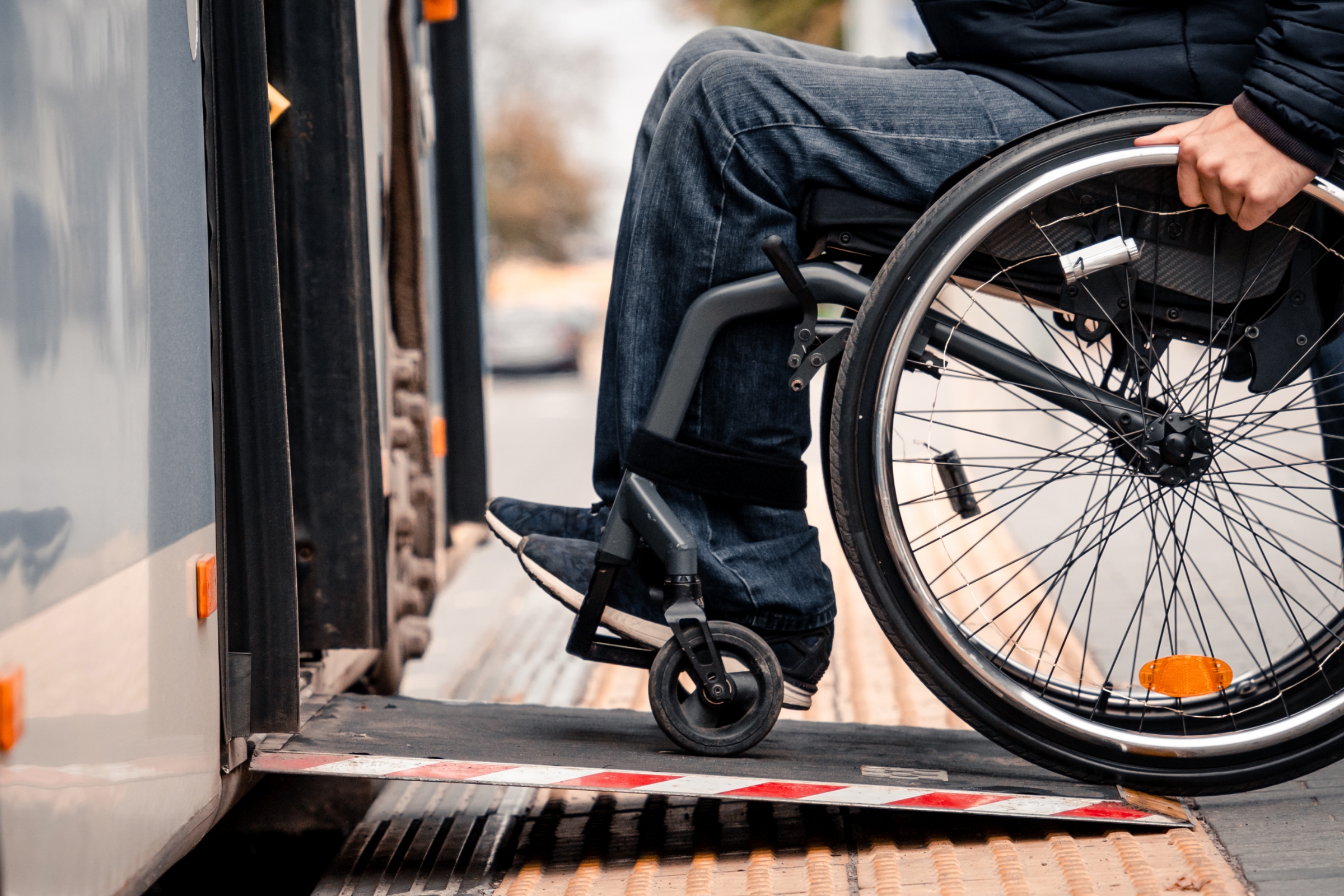 An individual utilizing the wheelchair ramp of a bus.