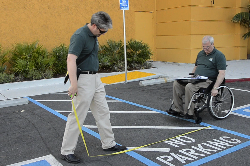 Doug Anderson and Jack Catlin measuring the accessible parking spaces.